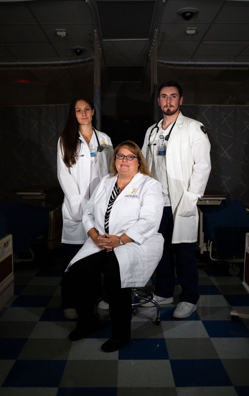 Dr. Crystal Shreeves and Nursing students Caelea Teel and Matt Lechalk stand in a darkened hospital room