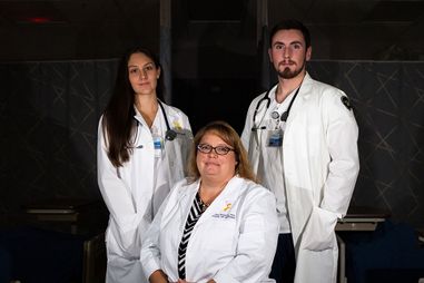 Dr. Sheaves and 2 nursing students in a darkened hospital room